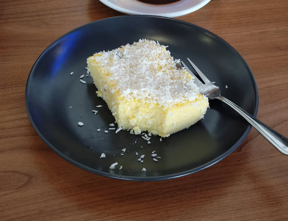 Poudine Mais mit Kokosraspeln auf einem dunklen Teller